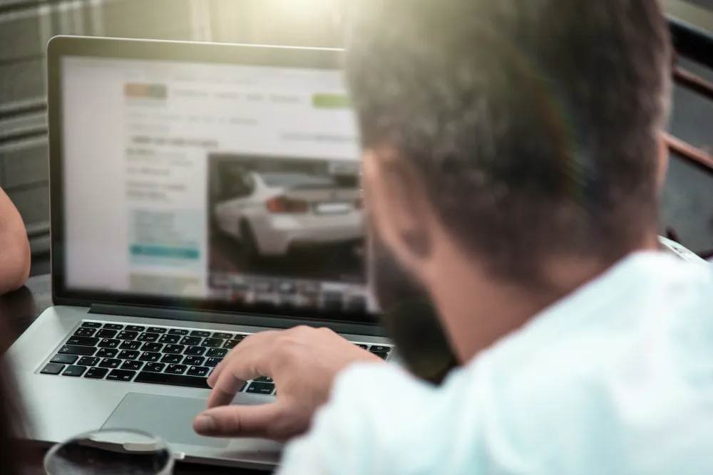Mann sucht ein Fahrzeug auf Autoverkaufsplattformen